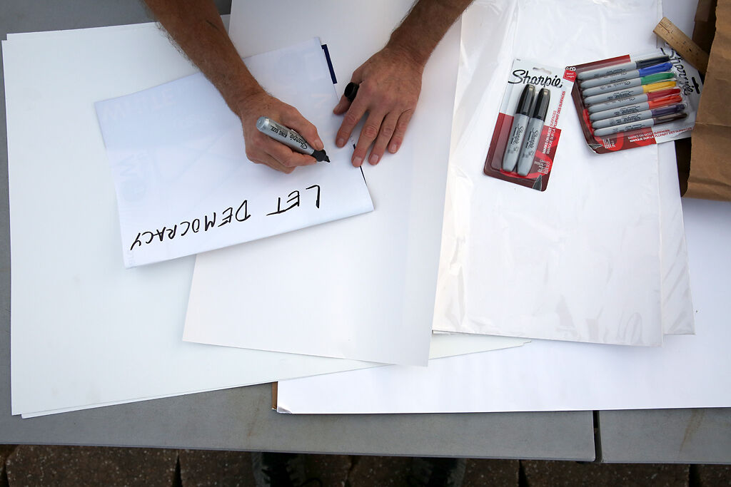 Jeff Stack writes a mock-up of a poster on Wednesday at the intersection of Broadway Blvd. and Providence Rd. in Columbia.